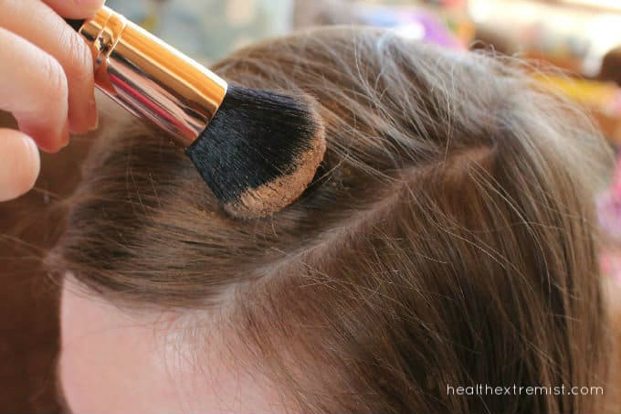 Girl applying DIY dry shampoo on hair