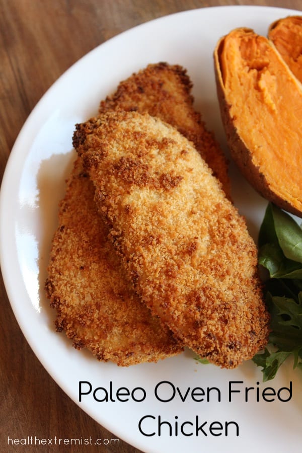 Plate with two slices of chicken with text overlay - paleo oven fried chicken