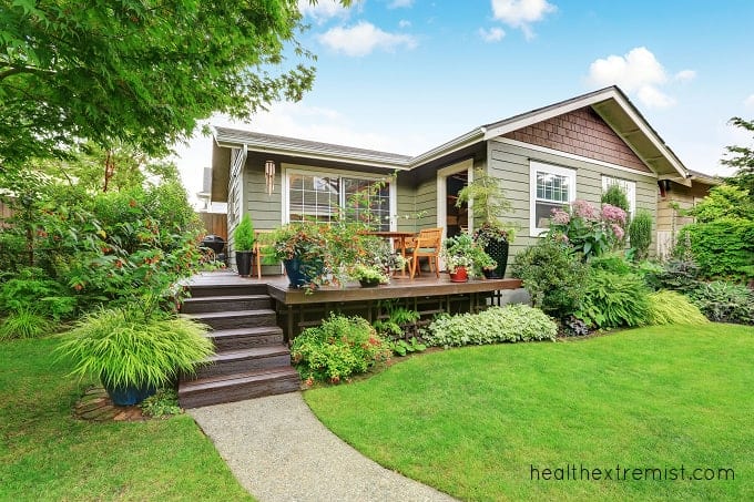 House with backyard and deck with potted plants and planted plants